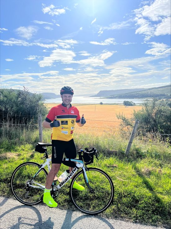 Danny James poses with his bicycle in an idyllic British landscape