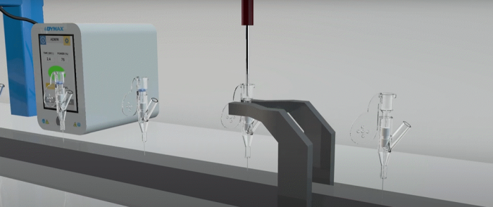 A catheter assembly line showing adhesive being dispensed