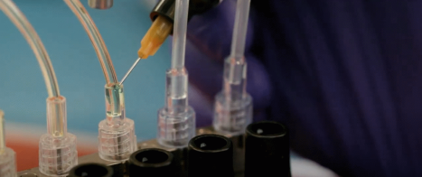 A row of plastic tubesets with adhesive being applied