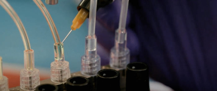 A row of plastic tubesets with adhesive being applied