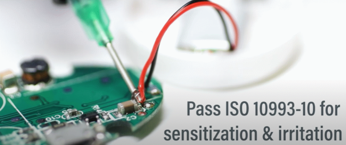 The interior of a wearable device showing adhesive being applied to electronics with the words "Pass ISO 10993-10 sensitisation test"