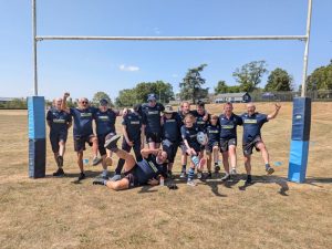 SEND rugby team and coaches posing between rugby posts