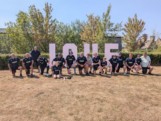 Oxford Wolves SEND rugby team in front of a sign saying LOVE